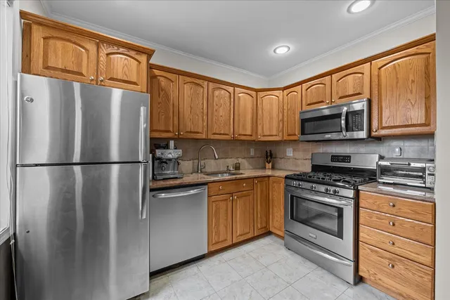 a kitchen with stainless steel appliances granite countertop a refrigerator stove a sink dishwasher and microwave