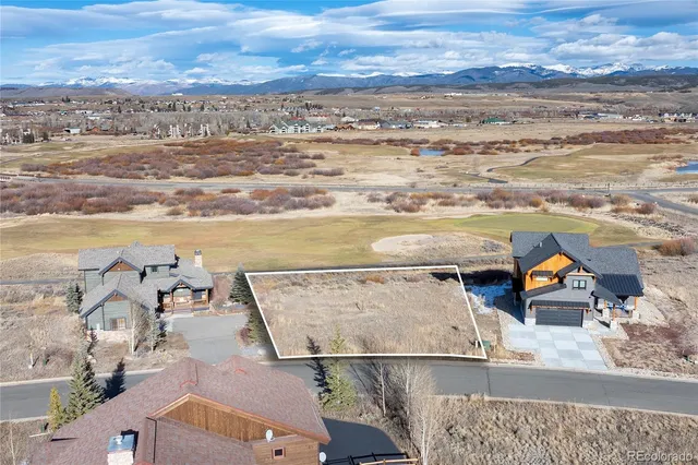 an aerial view of ocean and residential houses with outdoor space