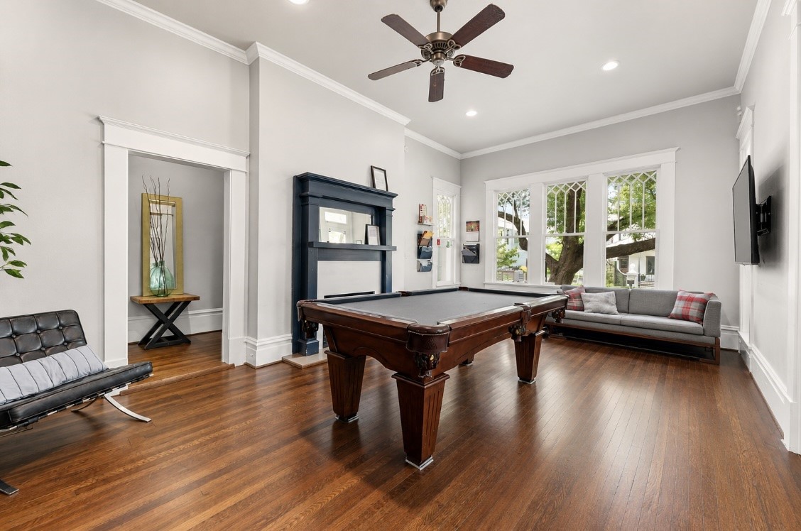 945 Harvard Street Houston, TX 77008 - Photo 17 of 47 Discover timeless elegance in this billiard room, featuring a cozy fireplace and stunning historic windows with intricate Prairie-style sashes.