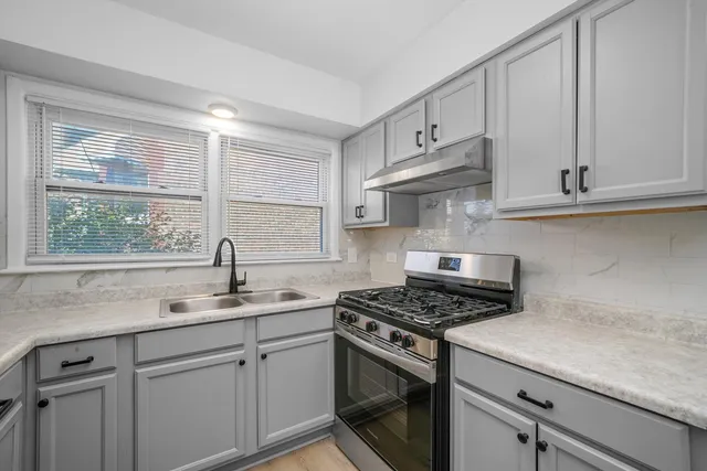 a kitchen with cabinets appliances a sink and a window