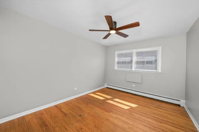 a view of a big room with wooden floor and windows