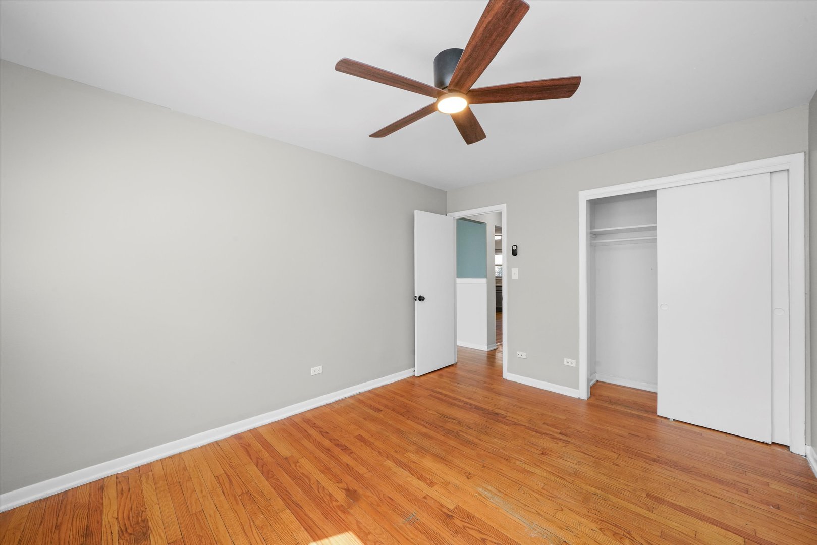 8917 South Cottage Grove Avenue Chicago, IL 60619 - Photo 8 of 17 a view of a big room with wooden floor and a ceiling fan