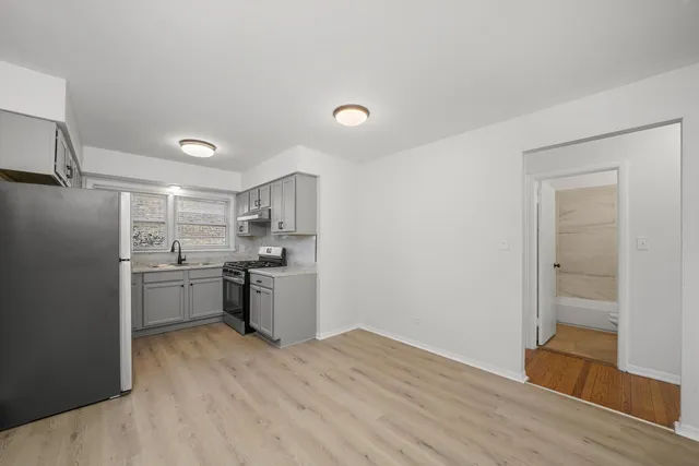 a kitchen with a refrigerator sink and stove top oven