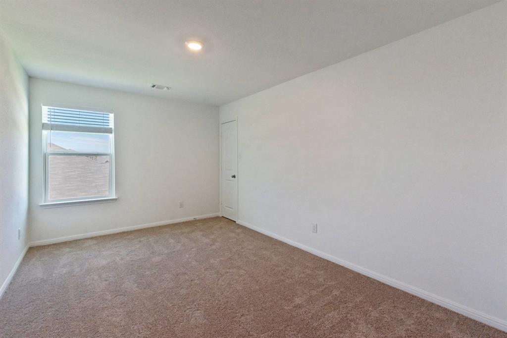16429 Farmhouse Lane Elgin, TX 78621 - Photo 18 of 22 Carpeted room with white walls, a single window with horizontal blinds, a white door, and a recessed ceiling light