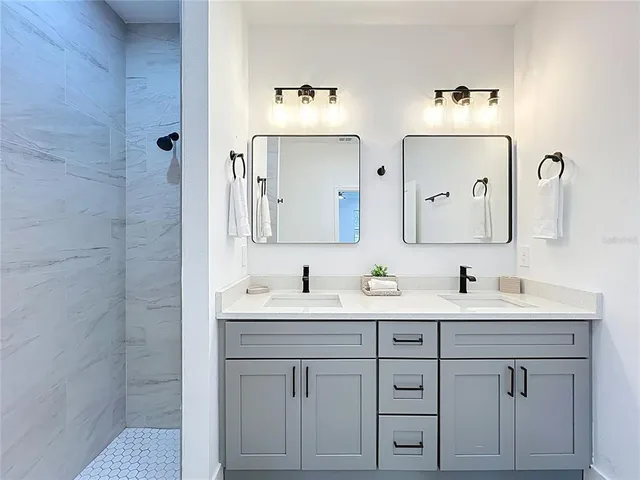 a bathroom with a double vanity sink mirror and