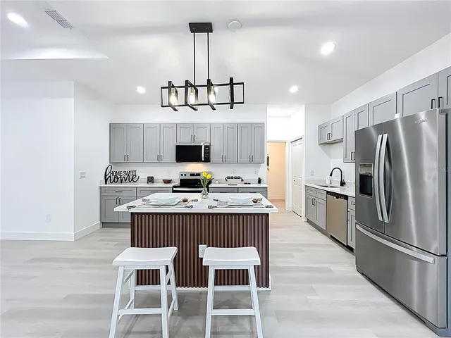a kitchen with kitchen island granite countertop a center island and stainless steel appliances
