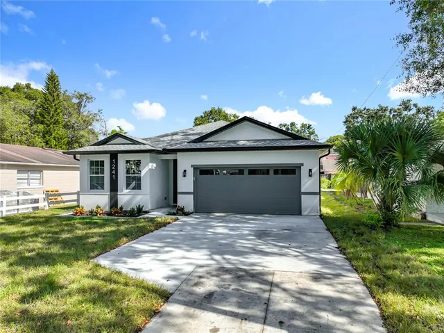 an aerial view of residential houses with outdoor space and trees