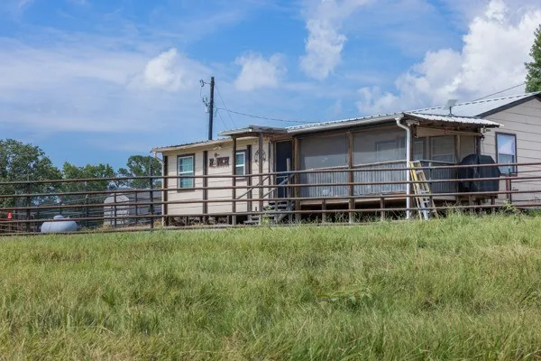 a view of a house with a yard and wooden fence