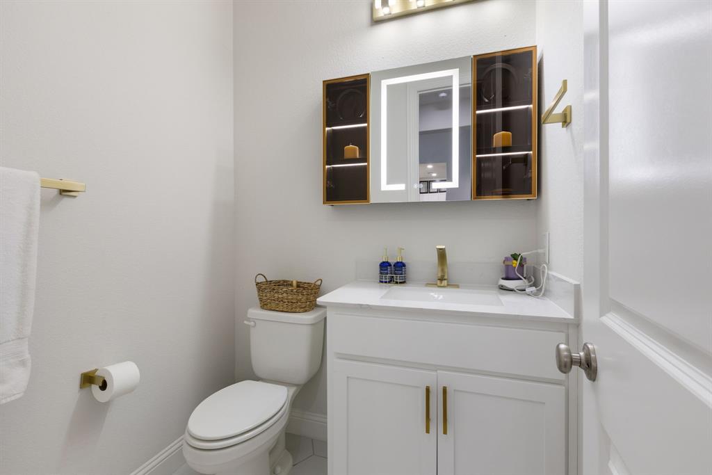 2116 Randas Way Rockwall, TX 75087 - Photo 18 of 40 a bathroom with a toilet sink a vanity and mirror