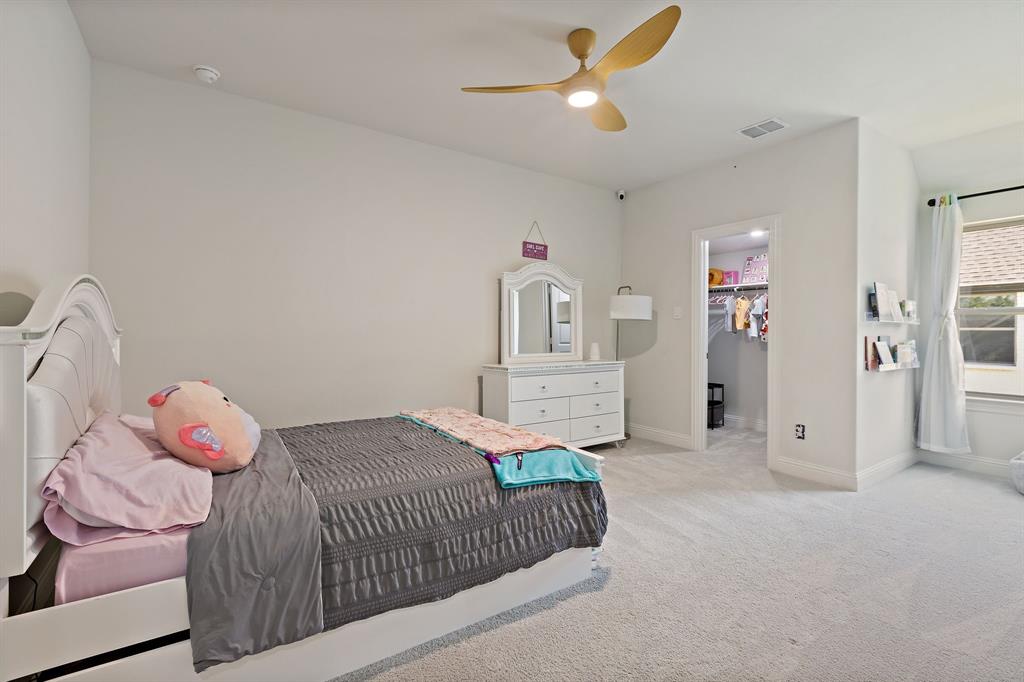 2116 Randas Way Rockwall, TX 75087 - Photo 26 of 40 a bedroom with a bed and a chandelier