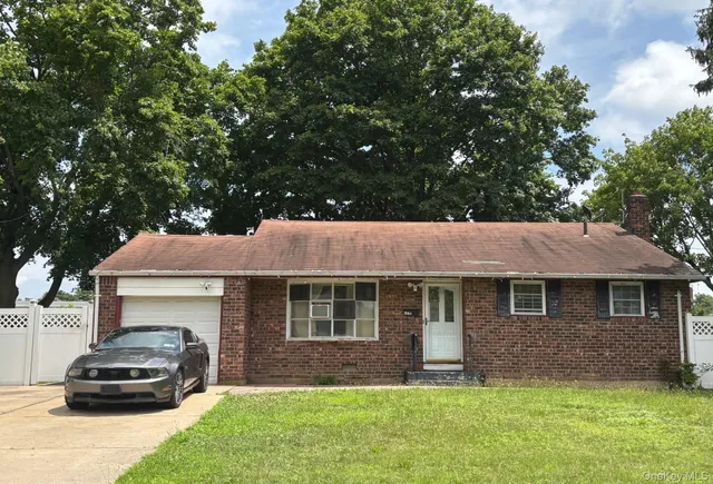 a front view of a house with a garden and trees