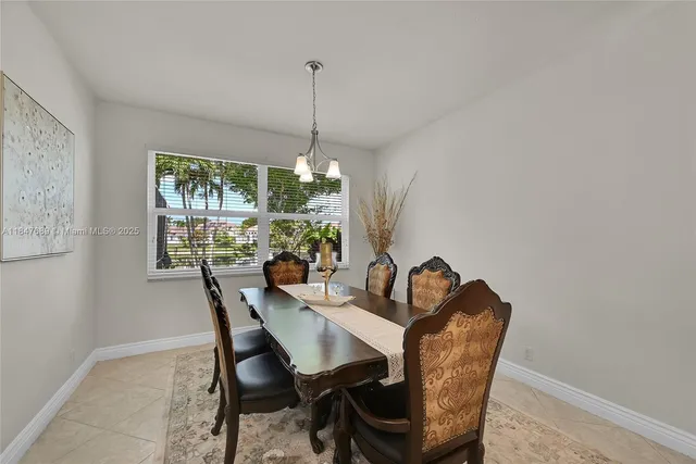 a dining room with furniture a chandelier and window