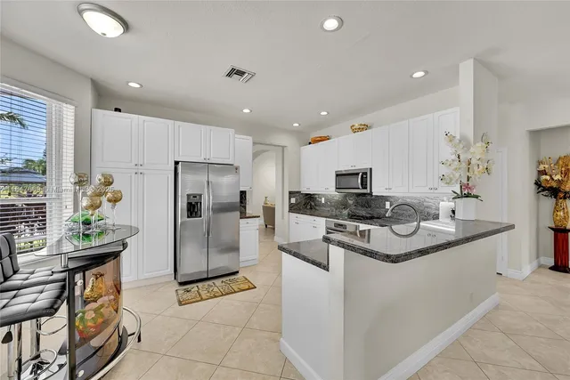 a kitchen with stainless steel appliances a stove a sink a microwave a refrigerator and cabinets