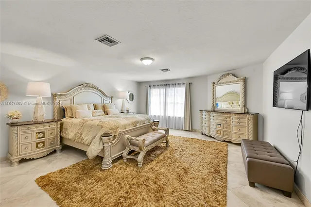 a bedroom with a large bed and wooden floor