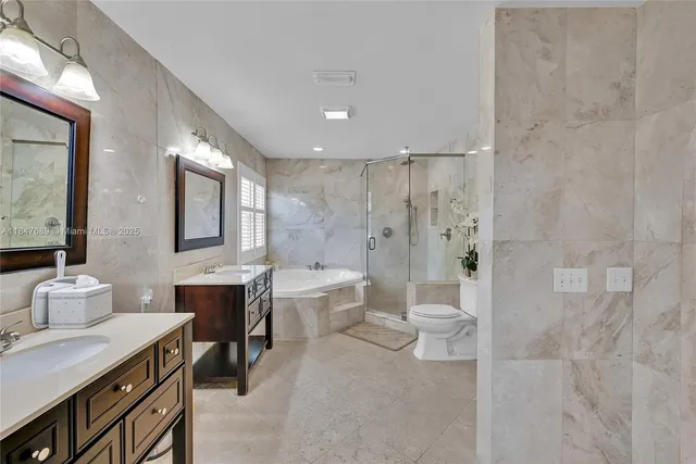 a bathroom with a double vanity sink mirror and bathtub