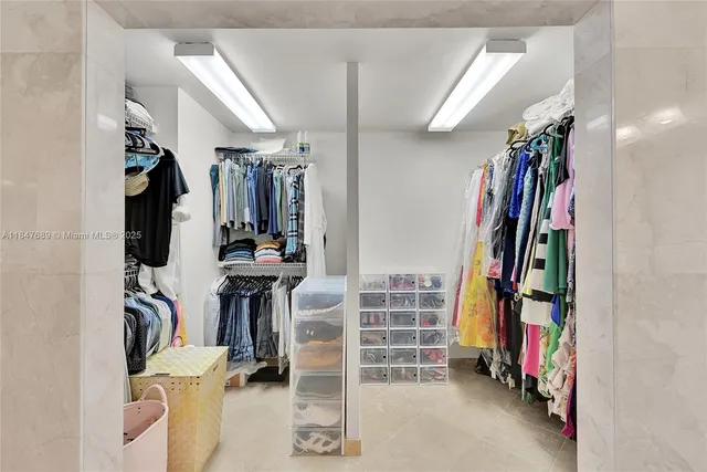 a view of a hallway with wooden floor and a bathroom