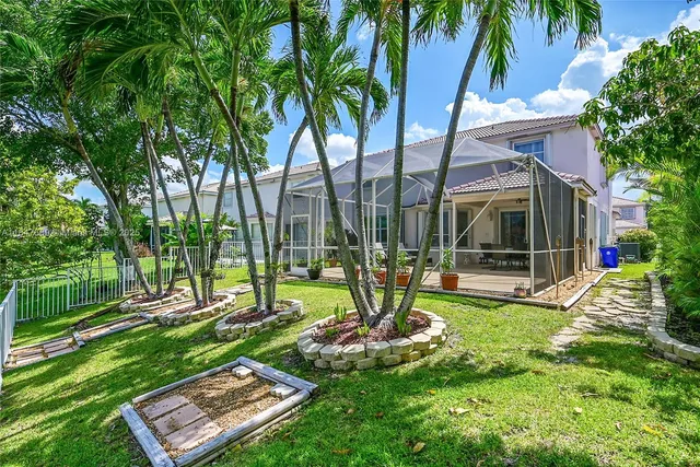 an aerial view of residential houses with outdoor space and trees