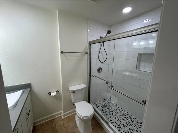 a bathroom with a toilet and a shower