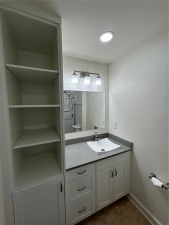 a bathroom with a sink vanity and mirror