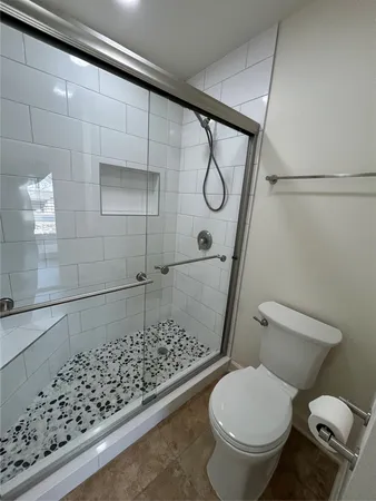 a bathroom with a toilet and a shower