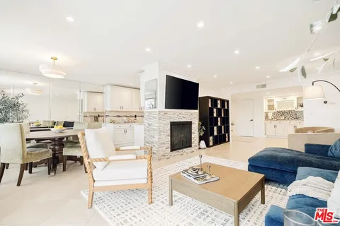 a living room with furniture a flat screen tv and kitchen view