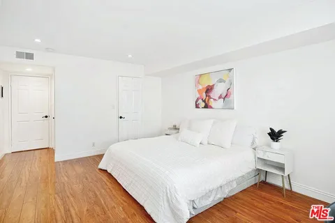 a bedroom with a bed and a painting on the wall