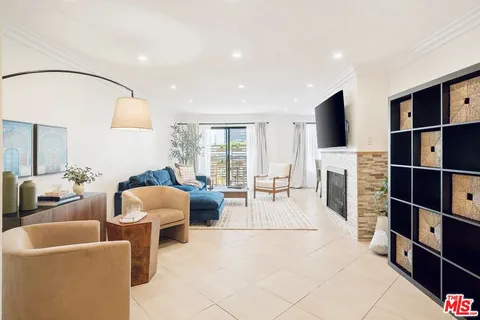 a living room with furniture a flat screen tv and a floor to ceiling window