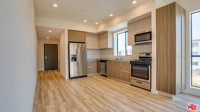 a kitchen with stainless steel appliances a refrigerator and a stove top oven
