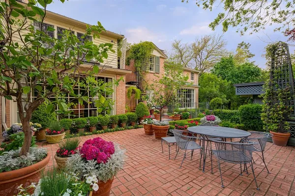 a view of a patio with couches table and chairs and potted plants