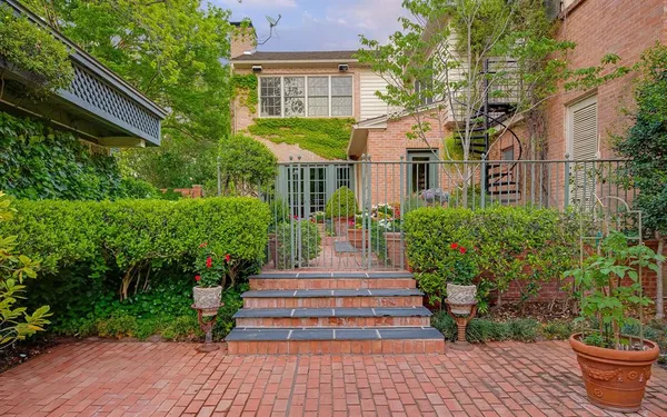 a front view of a house with garden and trees
