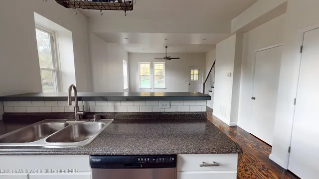 a kitchen with granite countertop a sink and a wooden cabinets