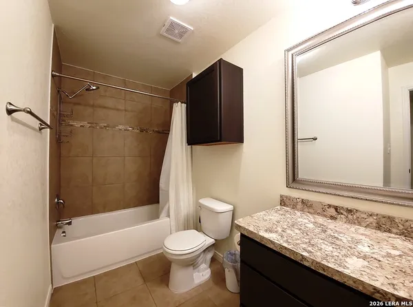 a bathroom with a granite countertop sink toilet and shower