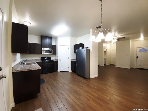 a kitchen with stainless steel appliances kitchen island granite countertop a refrigerator a stove and a sink