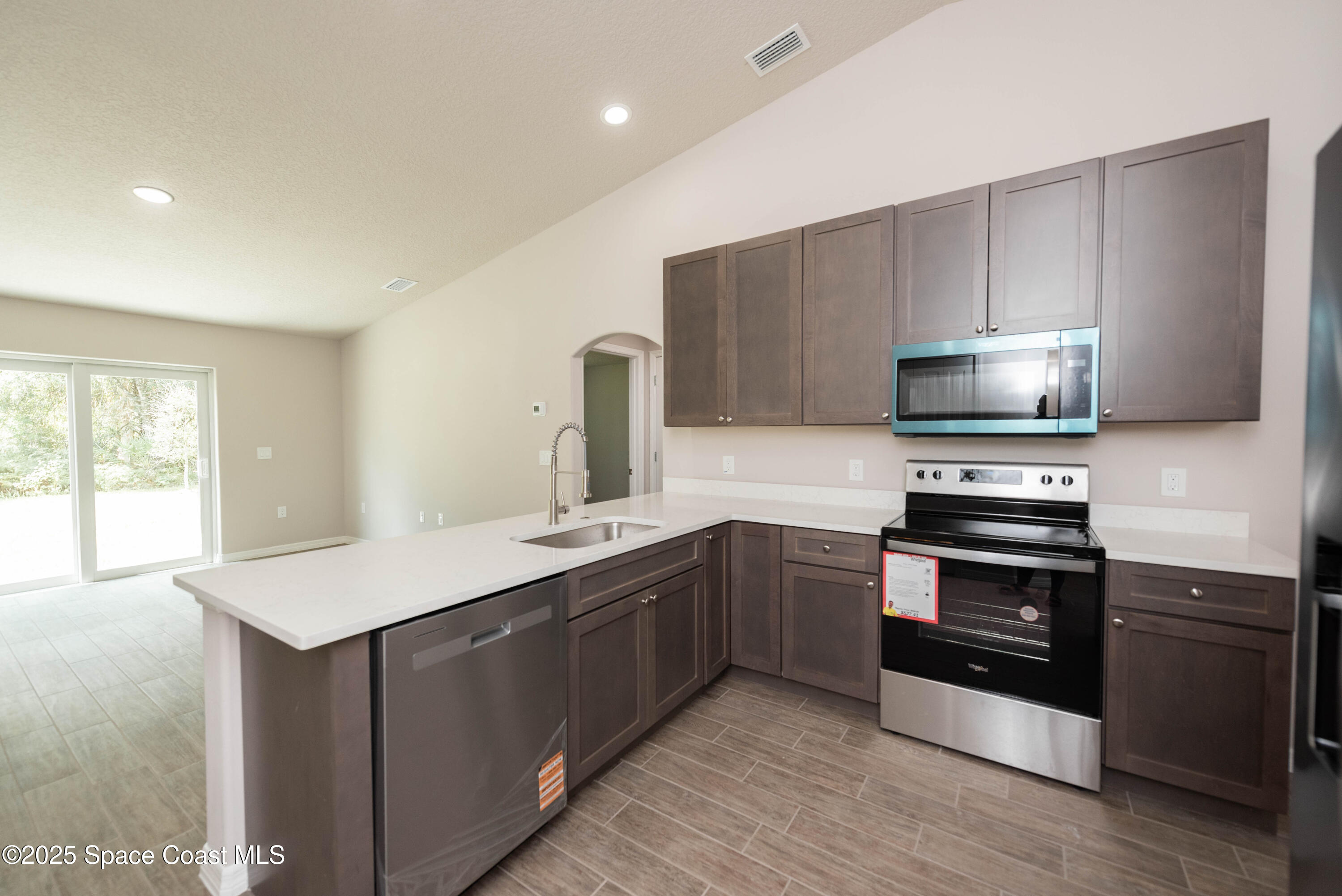 250 Frederick Street Southwest Palm Bay, FL 32908 - Photo 11 of 45 a kitchen with stainless steel appliances granite countertop a stove a sink and a microwave
