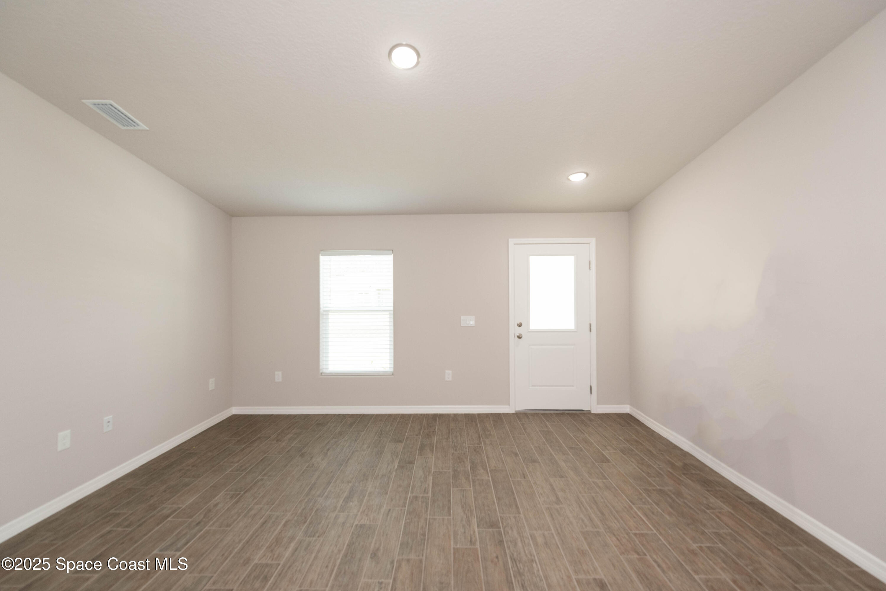 250 Frederick Street Southwest Palm Bay, FL 32908 - Photo 18 of 45 an empty room with wooden floor and windows
