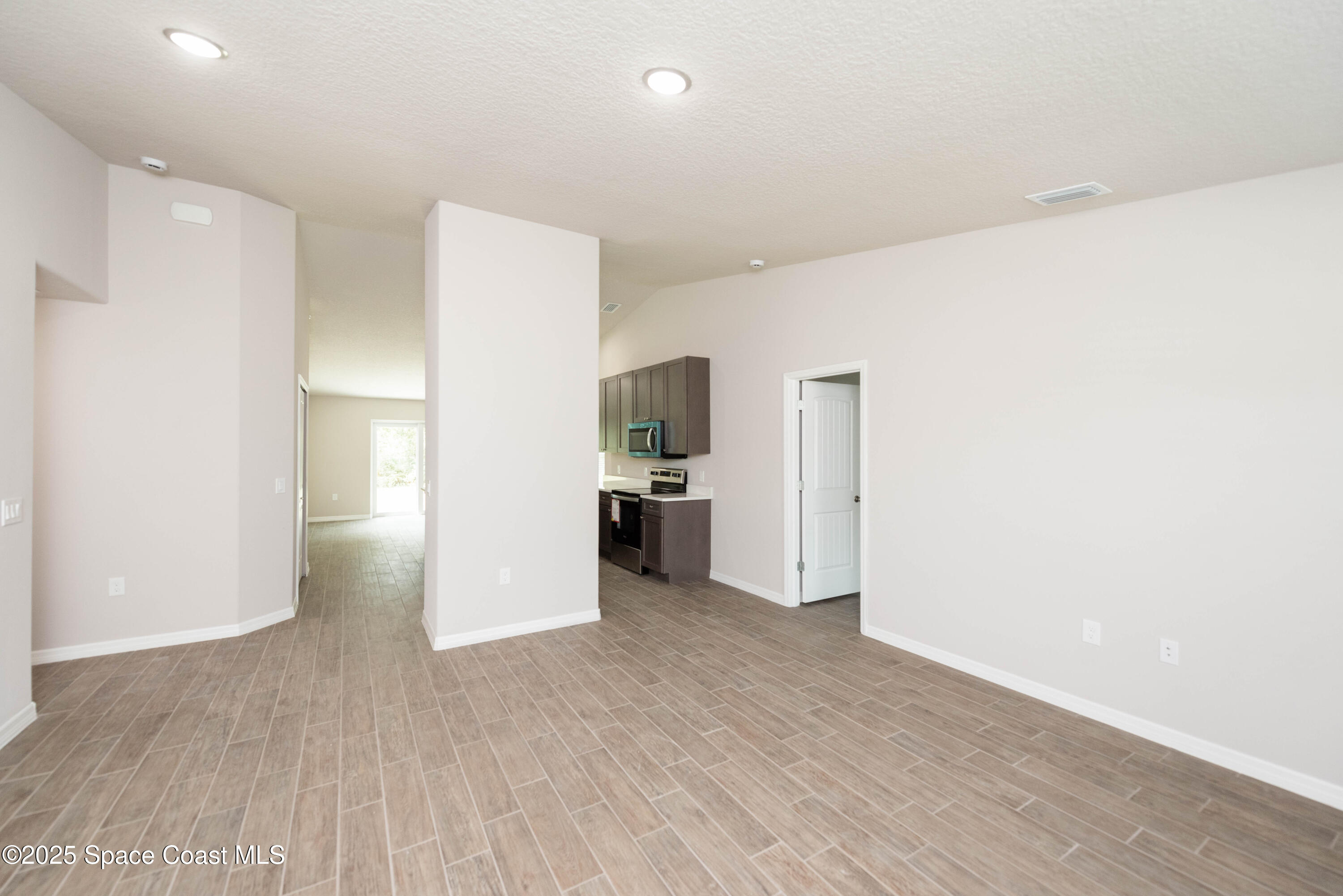 250 Frederick Street Southwest Palm Bay, FL 32908 - Photo 20 of 45 a view of a kitchen with refrigerator and an empty room