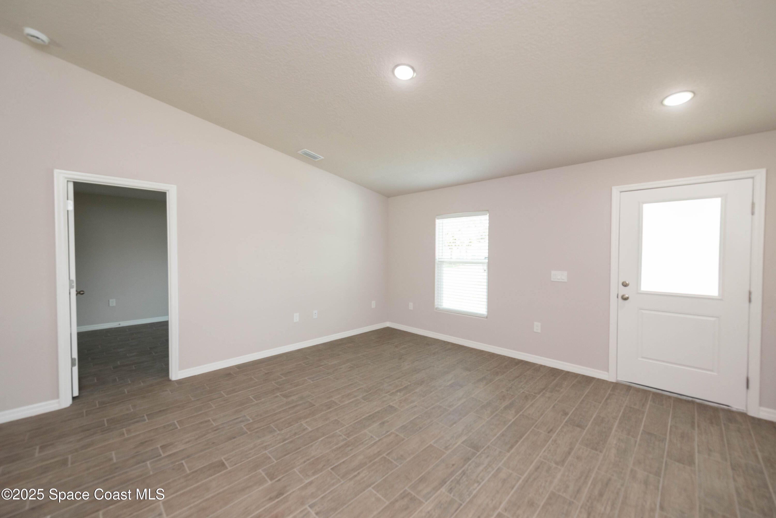 250 Frederick Street Southwest Palm Bay, FL 32908 - Photo 22 of 45 an empty room with wooden floor and windows
