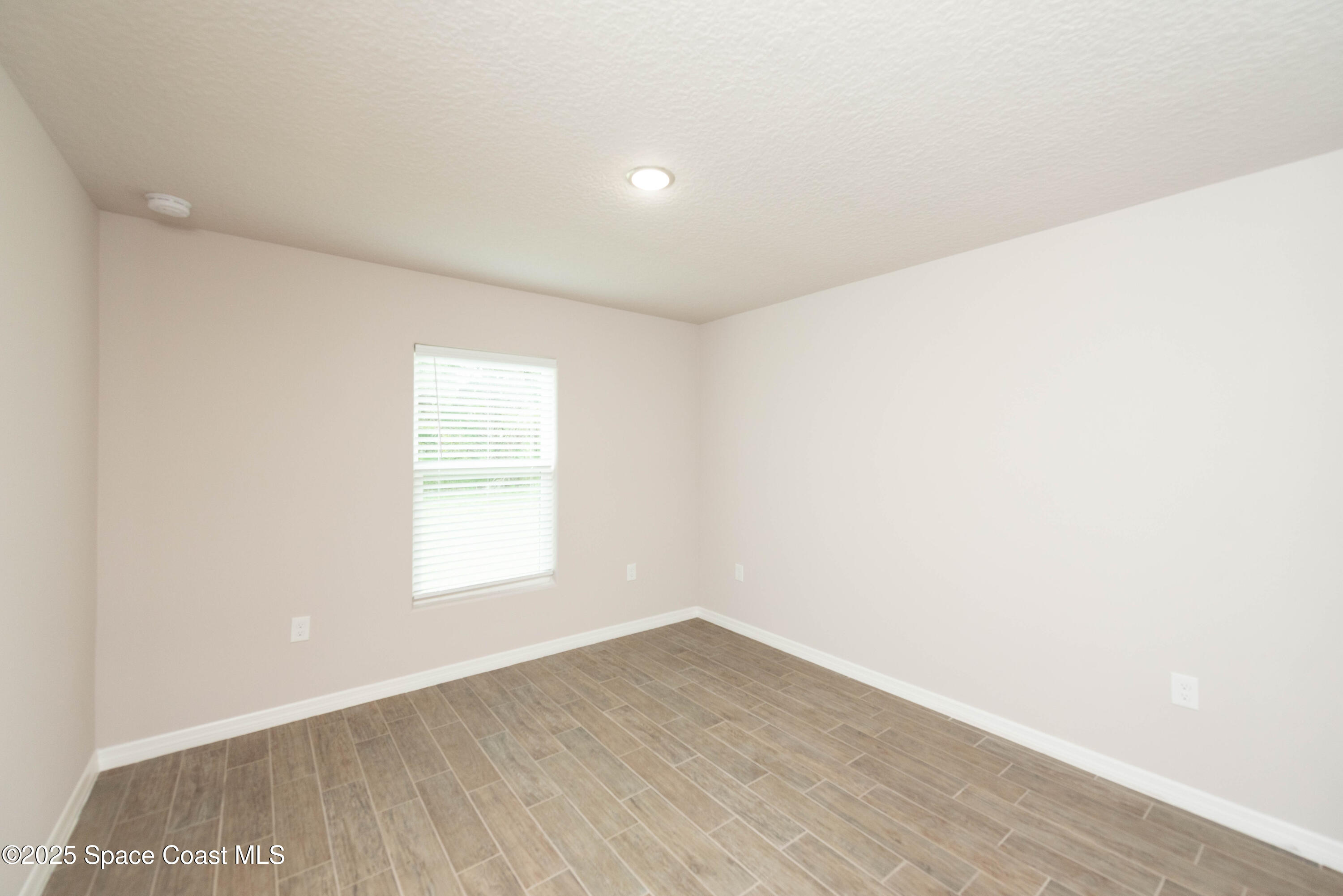 250 Frederick Street Southwest Palm Bay, FL 32908 - Photo 26 of 45 an empty room with wooden floor and windows