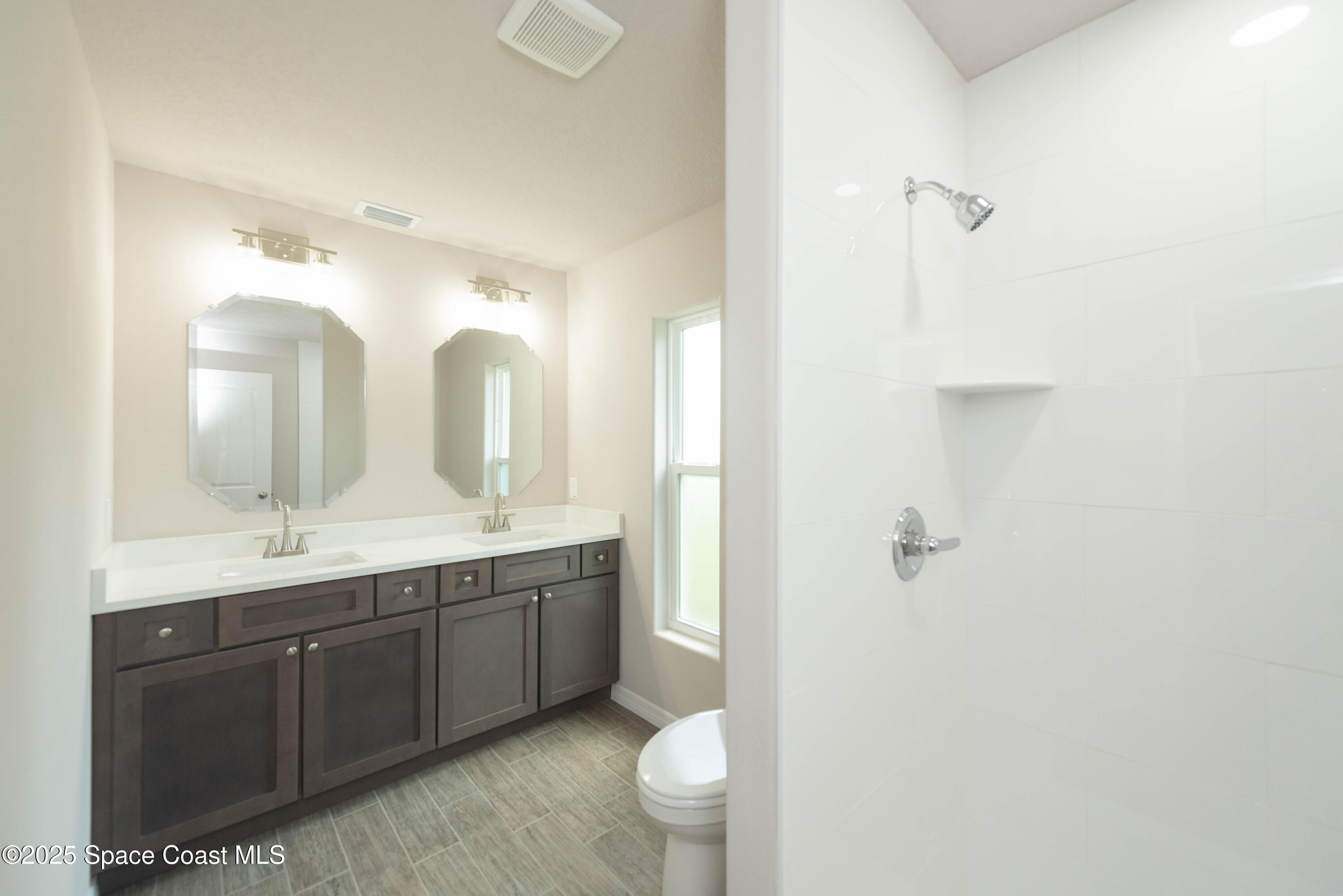 250 Frederick Street Southwest Palm Bay, FL 32908 - Photo 30 of 45 a bathroom with a double vanity sink toilet and a mirror