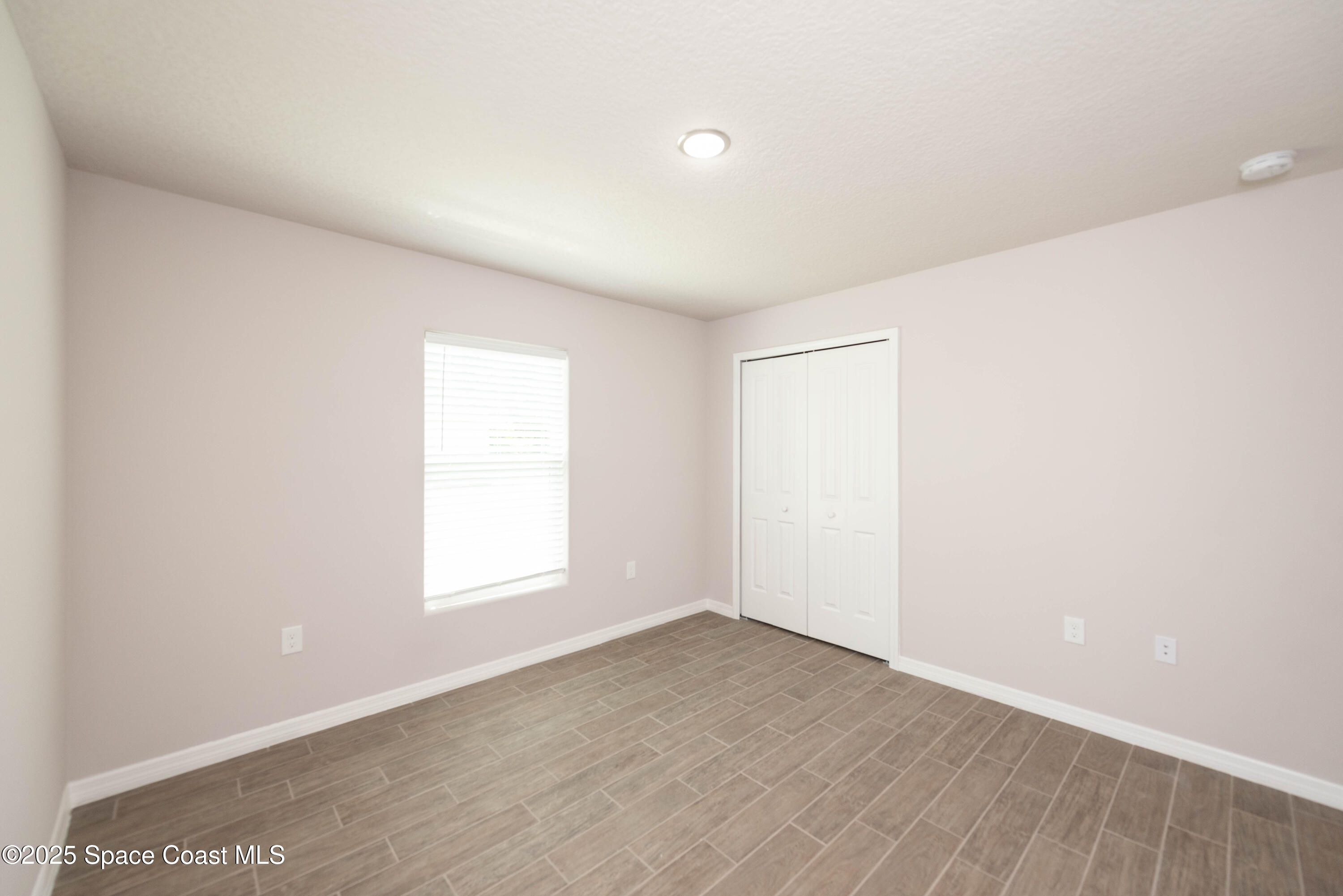 250 Frederick Street Southwest Palm Bay, FL 32908 - Photo 37 of 45 an empty room with wooden floor and window