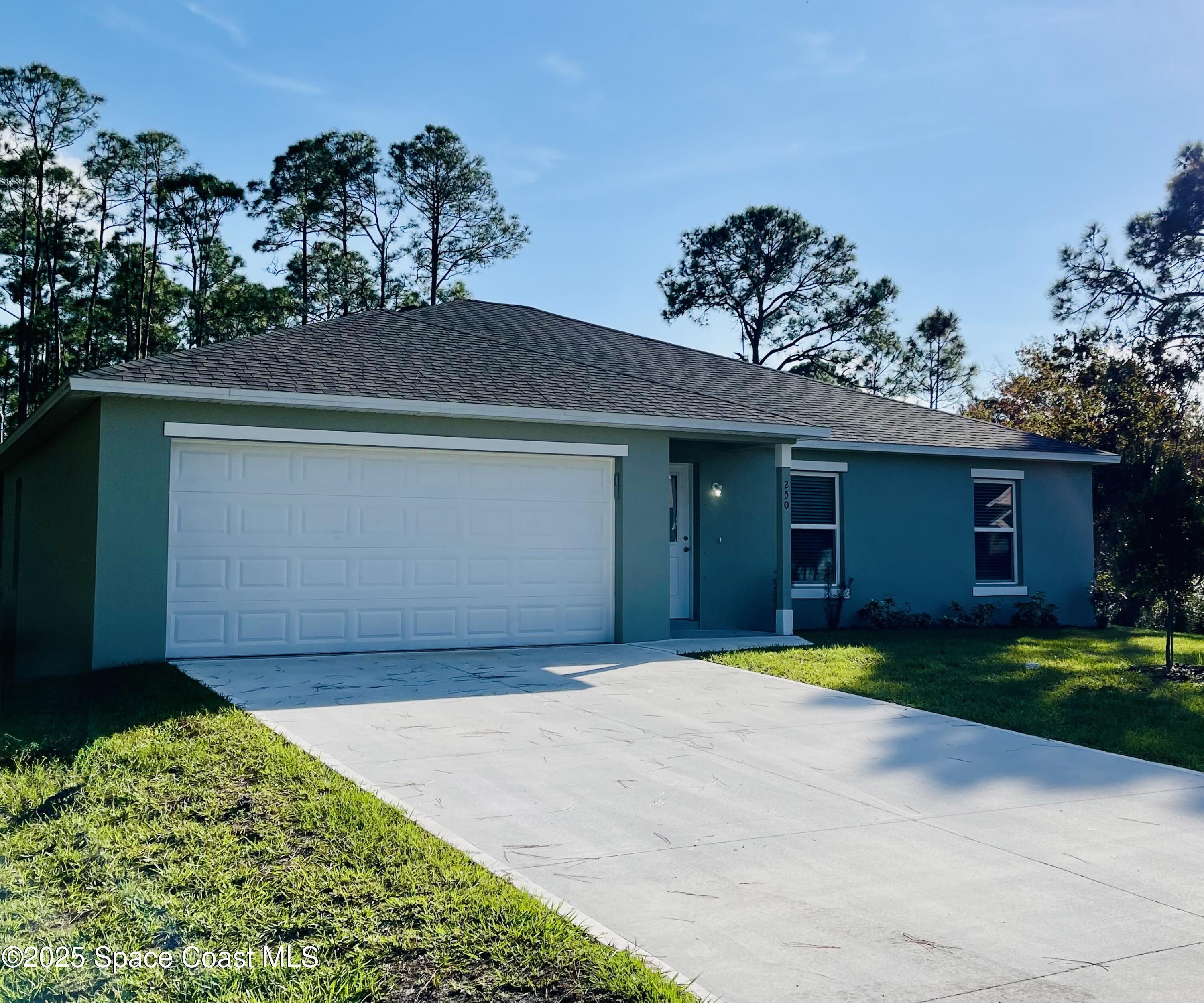 250 Frederick Street Southwest Palm Bay, FL 32908 - Photo 42 of 45 a front view of a house with a yard and garage