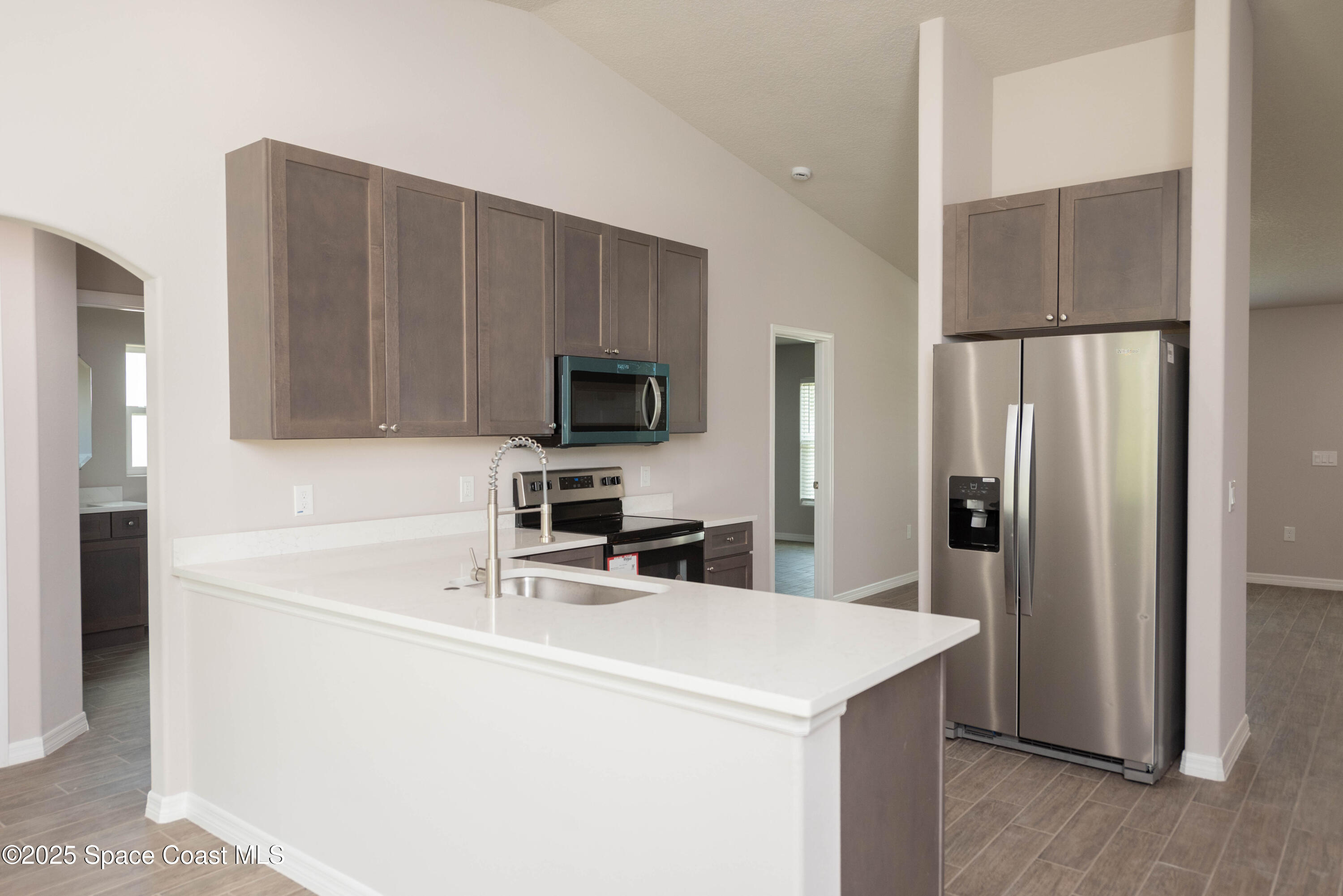 250 Frederick Street Southwest Palm Bay, FL 32908 - Photo 5 of 45 a kitchen with a sink a microwave a refrigerator and cabinets