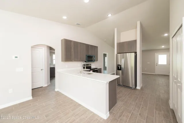 a kitchen with stainless steel appliances a refrigerator and a stove top oven