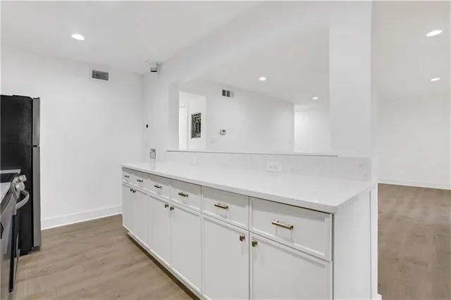 a view of a kitchen with white cabinets