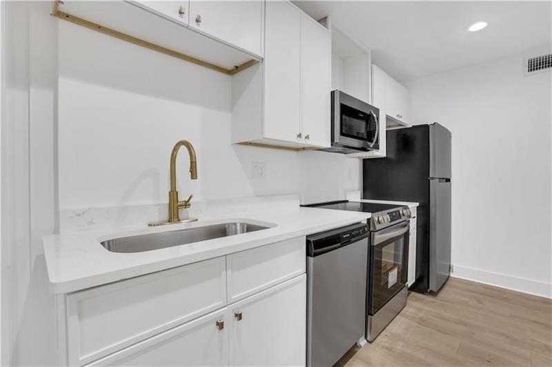 2396 Lawrenceville Highway, Unit V Decatur, GA 30033 - Photo 14 of 27 a kitchen with stainless steel appliances granite countertop a sink stove top oven and refrigerator