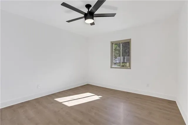 an empty room with a window and a ceiling fan