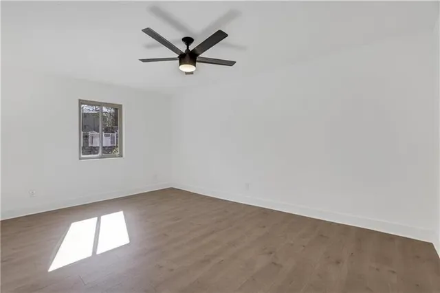 an empty room with a window and a fan