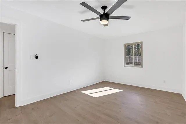 an empty room with a window and a fan