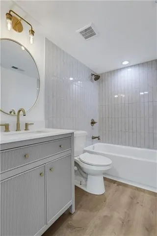 a bathroom with a toilet a sink a mirror and bathtub