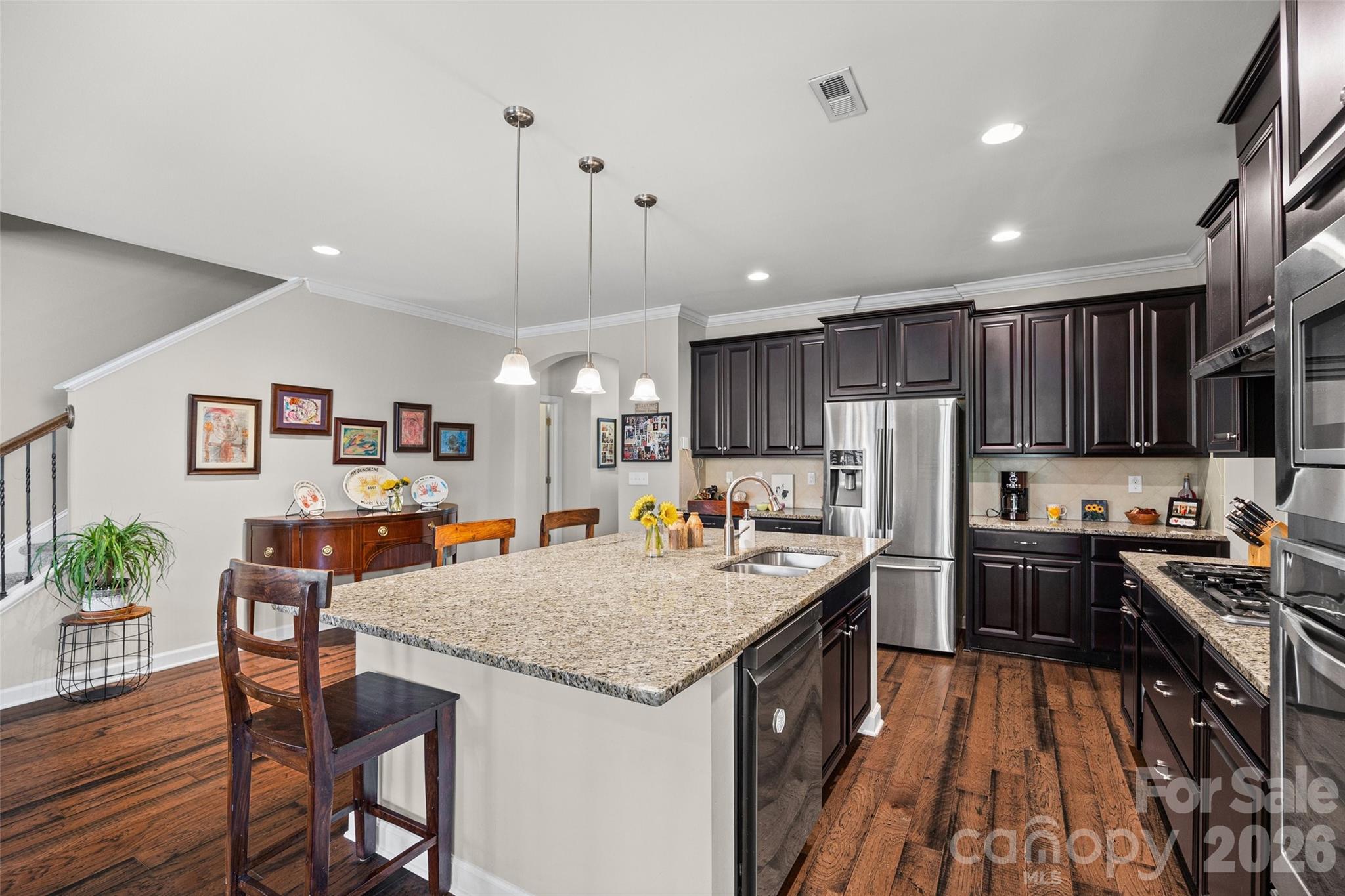 2054 Lometa Road York, SC 29745 - Photo 10 of 45 a kitchen with granite countertop kitchen island stainless steel appliances a refrigerator a stove a sink a dining table and chairs with wooden floor